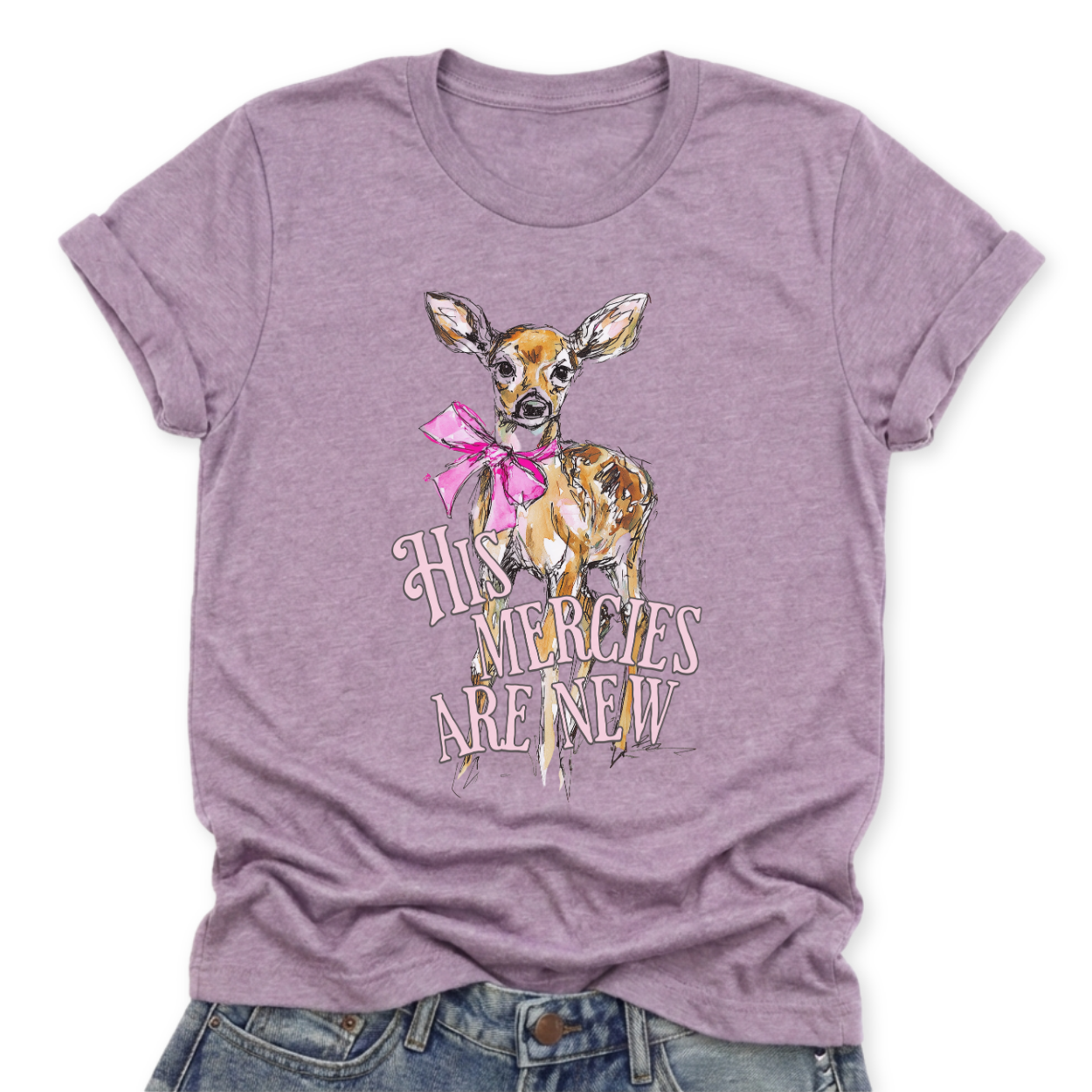 Christian Easter scripture graphic on a Bella Canvas t-shirt. The design features an illustrated fawn with soft watercolor-style detailing, accented with a bright pink bow for a feminine spring touch. The phrase “His Mercies Are New” appears in vintage-inspired lettering beneath the deer, referencing Lamentations 3:23 and the renewal message of Easter.