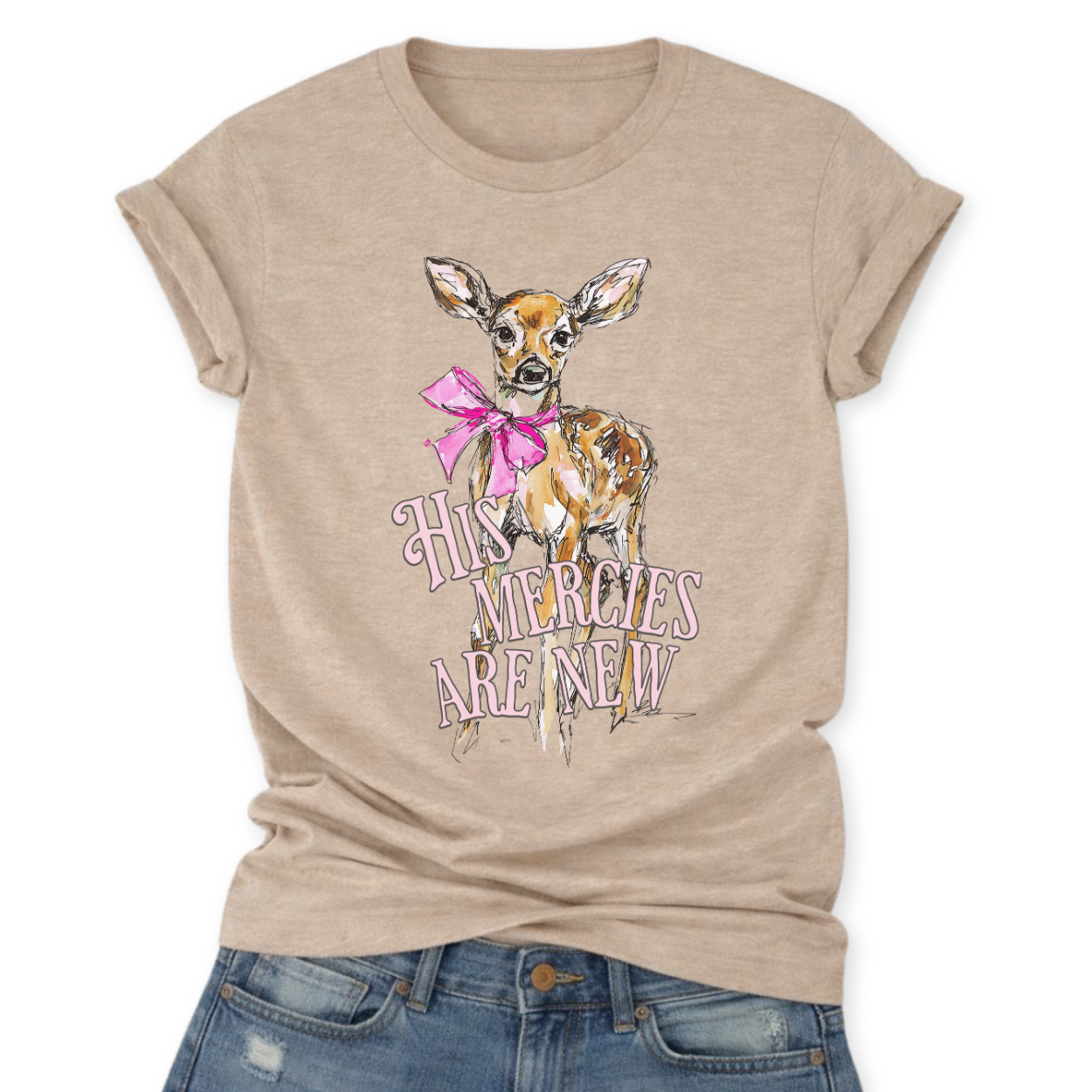 Christian Easter scripture graphic on a Bella Canvas t-shirt. The design features an illustrated fawn with soft watercolor-style detailing, accented with a bright pink bow for a feminine spring touch. The phrase “His Mercies Are New” appears in vintage-inspired lettering beneath the deer, referencing Lamentations 3:23 and the renewal message of Easter.