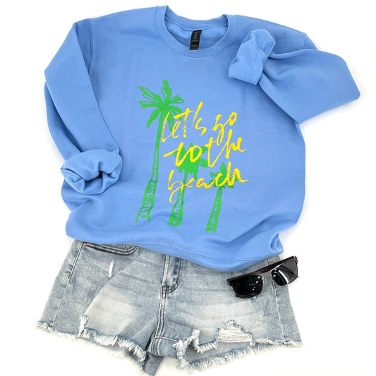 Blue sweatshirt with palm tree design and text that says let's go to the beach.  paired with denim shorts and sunglasses on a white background