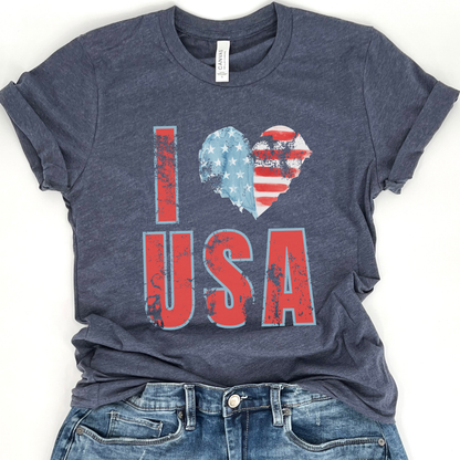 A navy blue t-shirt with a graphic that says 'I love USA' where the word 'love' forms a heart shape with the American flag colors.