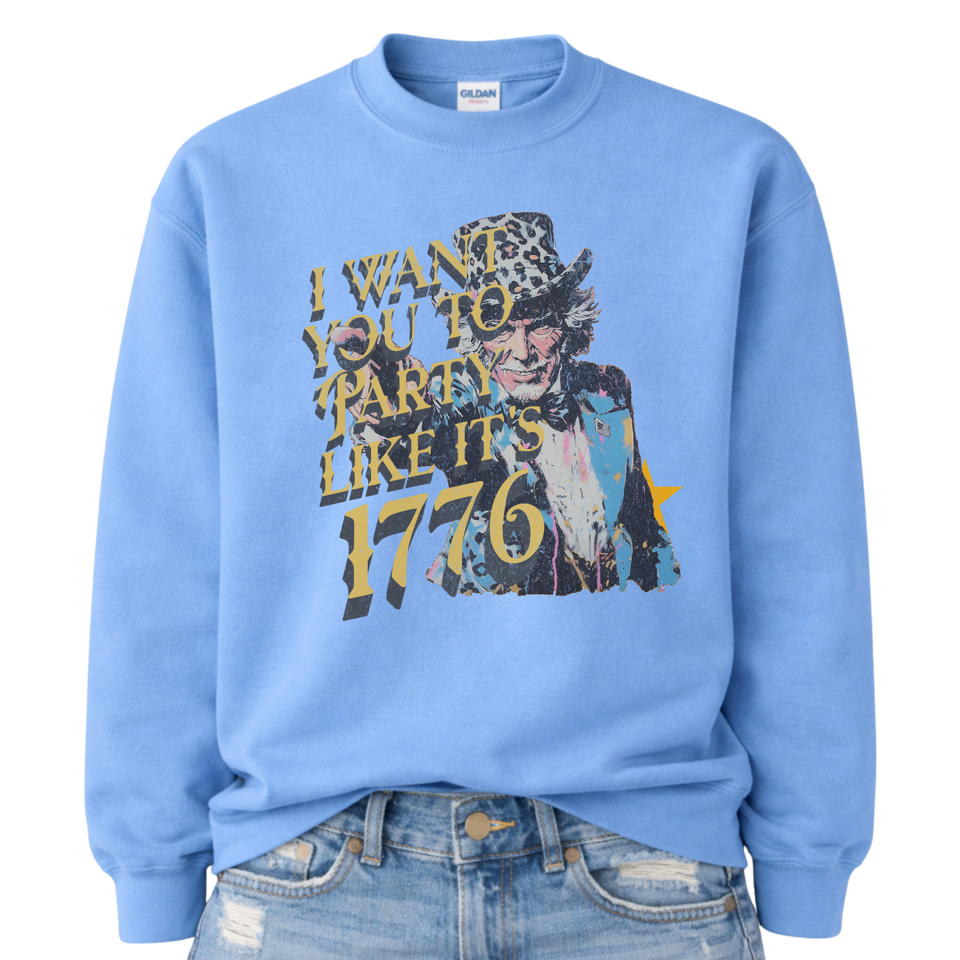 Patriotic Uncle Sam graphic on a blue sweatshirt. The design features a distressed illustrated portrait of Uncle Sam wearing a patterned top hat, paired with bold vintage-style text reading “I Want You to Party Like It’s 1776.” Layered textures, muted patriotic tones, and worn ink details give the artwork a retro Americana feel. A bold, playful patriotic design suited for Fourth of July, summer celebrations, and USA-themed seasonal collections.