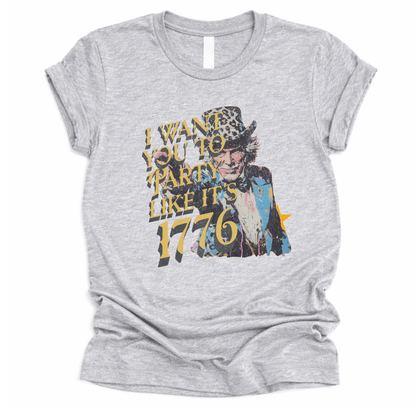 Vintage patriotic 1776 graphic on a gray t-shirt. The design features an illustrated Uncle Sam portrait with distressed textures and bold gold lettering reading “I Want You to Party Like It’s 1776.” The artwork blends Revolutionary War imagery with modern, playful Fourth of July messaging, creating a nostalgic Americana look ideal for Independence Day and summer patriotic collections.