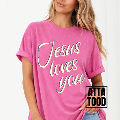 Person wearing a pink t-shirt with 'Jesus loves you' text, brand 'ATTA TOOD' visible. Jesus loves you