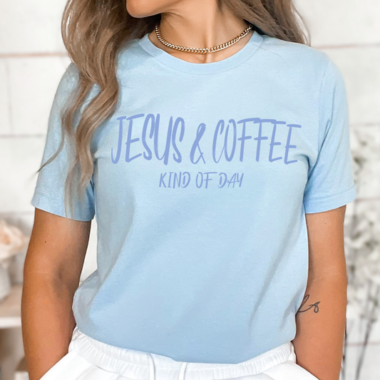 Light blue t-shirt with 'Jesus & Coffee Kind of Day' text worn by a person.