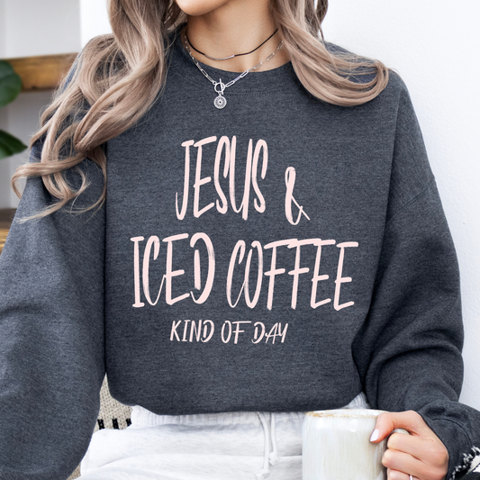 Person wearing a dark gray sweatshirt with 'Jesus & Iced Coffee Kind of Day' text, holding a white mug.