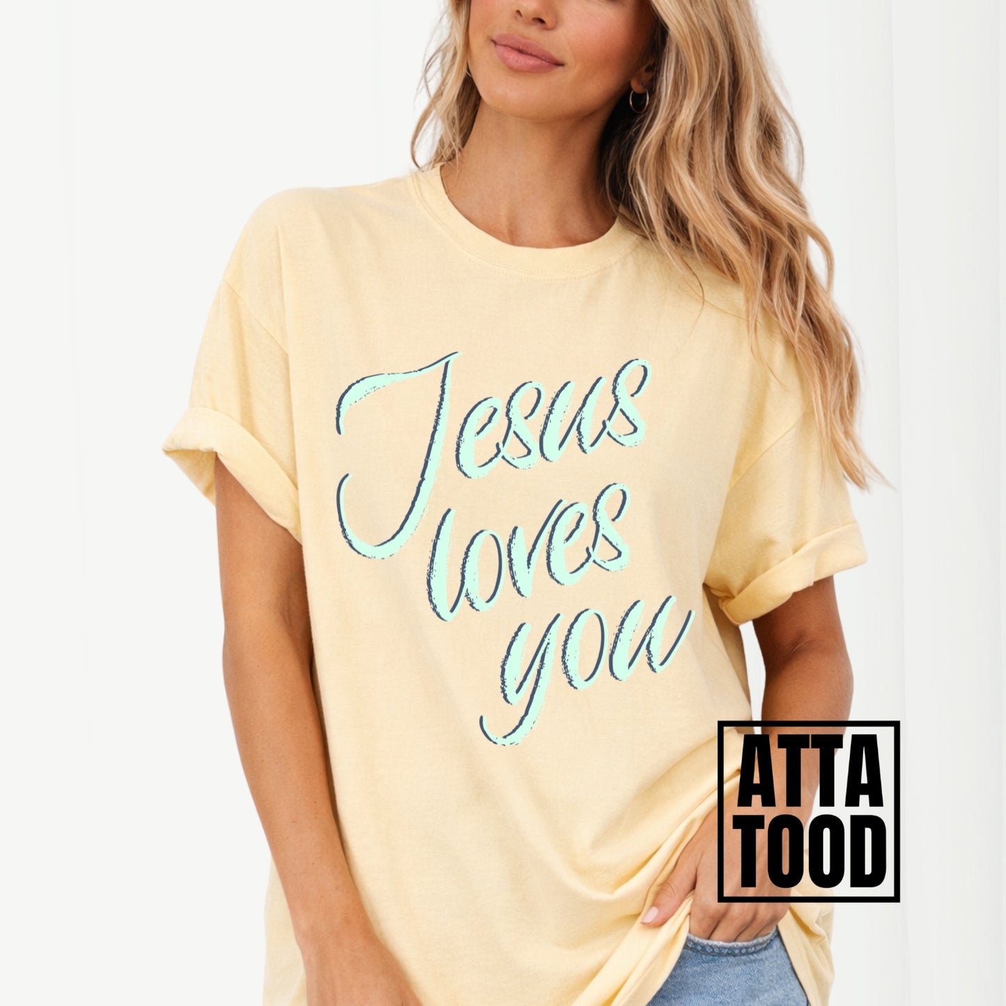 Person wearing a yellow t-shirt with 'Jesus loves you' text, brand 'ATTA TOOD' visible. Jesus loves you