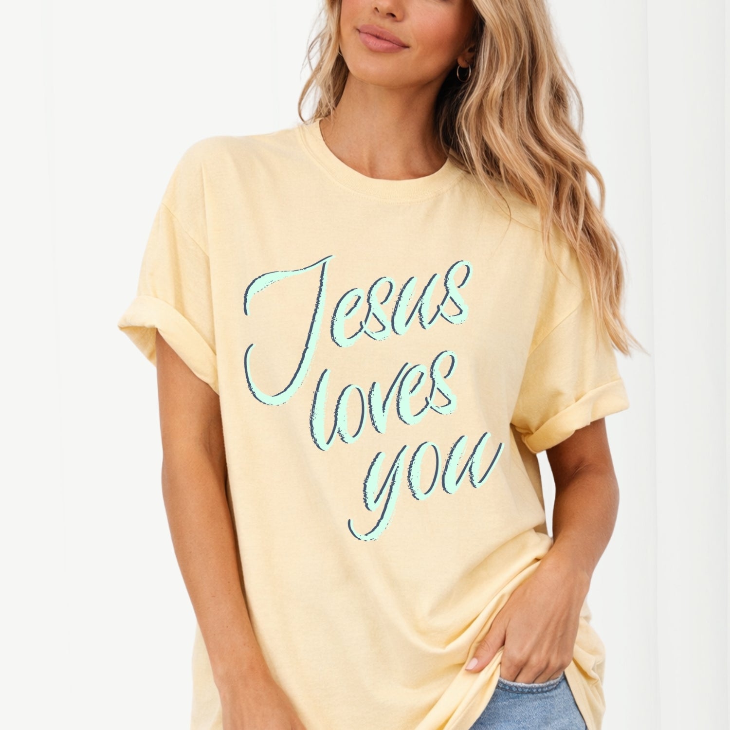 Woman wearing a yellow t-shirt with 'Jesus loves you' text on a white background
