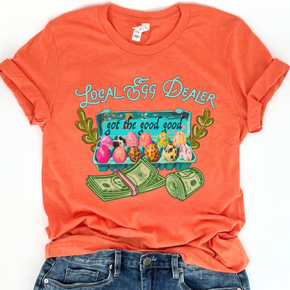 Orange t-shirt with 'Local Egg Dealer' graphic design on a white background