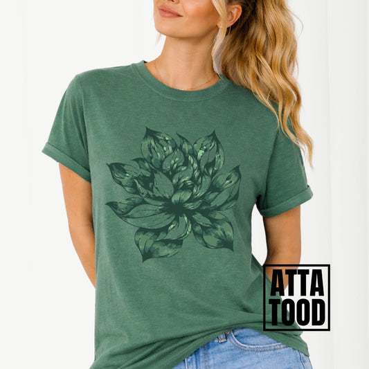 light green t-shirt with a large green floral design worn by a person, with 'ATTA TOOD' branding.