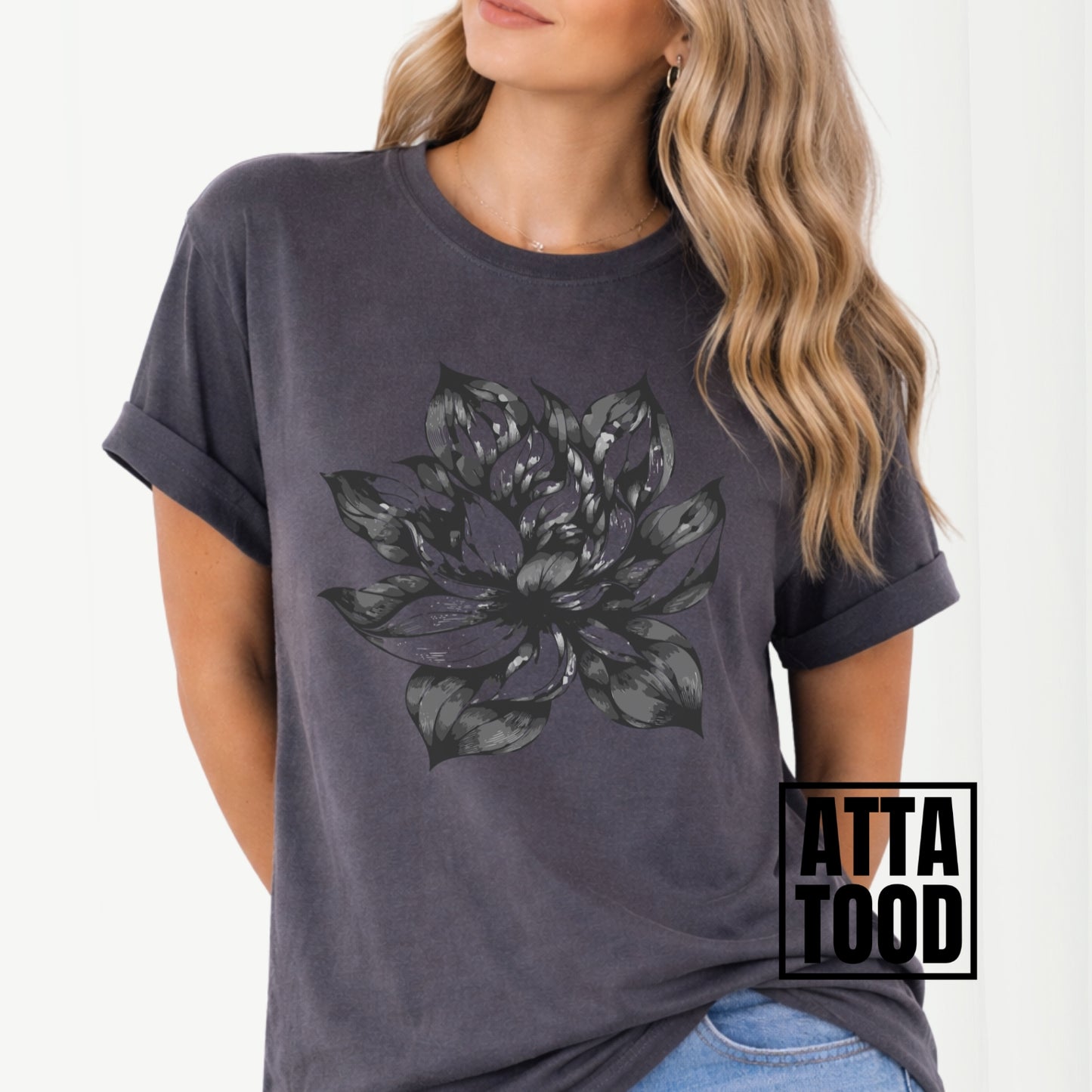dark gray t-shirt with a large gray floral design worn by a person, with 'ATTA TOOD' branding.
