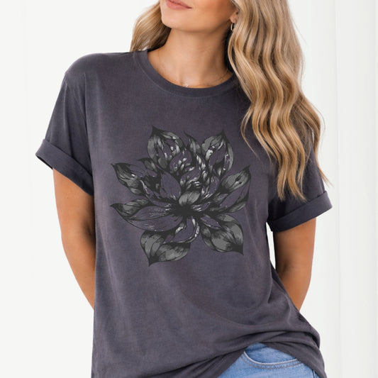 Person wearing a dark gray t-shirt with a black floral design on a white background
