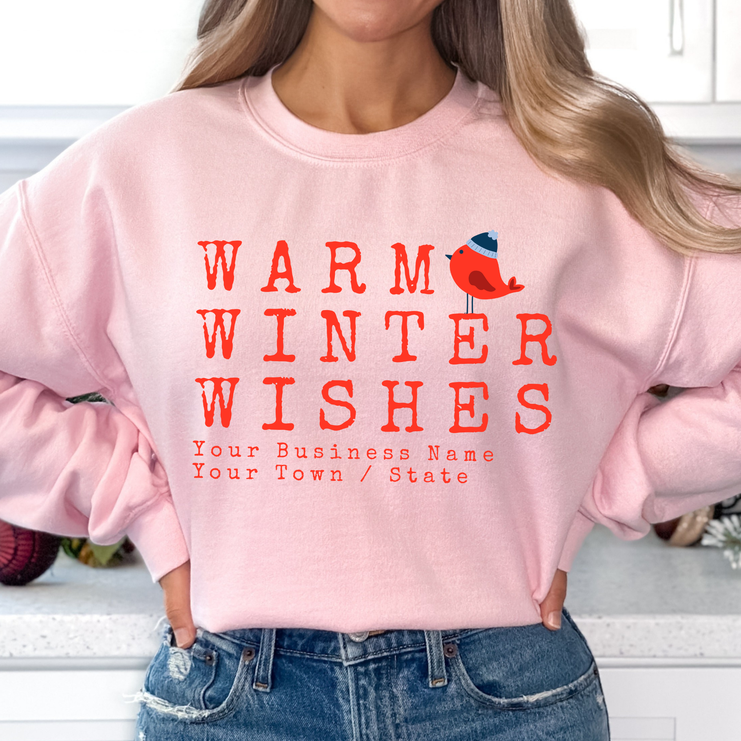 Warm winter wishes written in red with a little red bird wearing a blue beanie hat.  light pink sweatshirt.  Customize with business name, zip code, town, state or all. 
