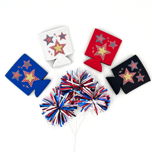 Red, Blue, Black and White collapsible can cooler displayed on a white background with a red, white, and blue metallic pom pom in the foreground. The graphic features red, white, and blue patchwork style stars with gingham patterns and small sparkles, creating a patriotic Americana star design printed on the front of the drink sleeve style can cooler.