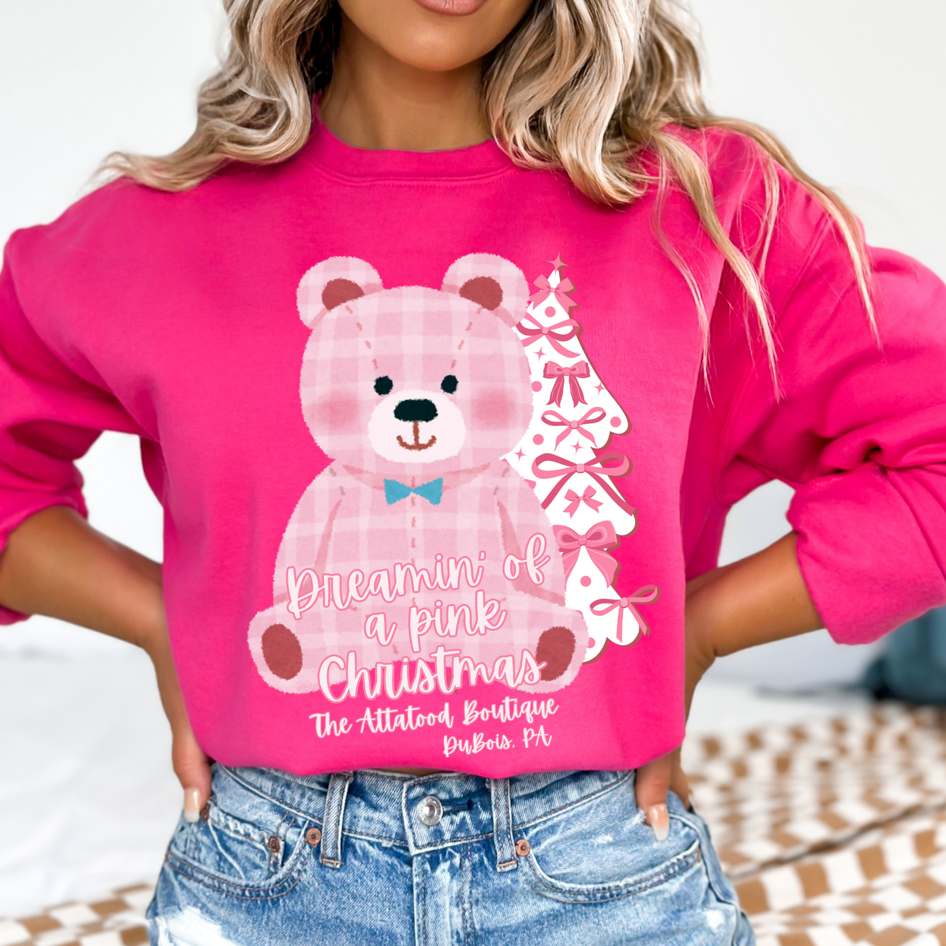 oversize pink plaid teddybear with white Christmas tree with pink bows on a heliconia pink sweatshirt. Text says Dreamin of a pink Christmas Customize with business name, city, state or both.