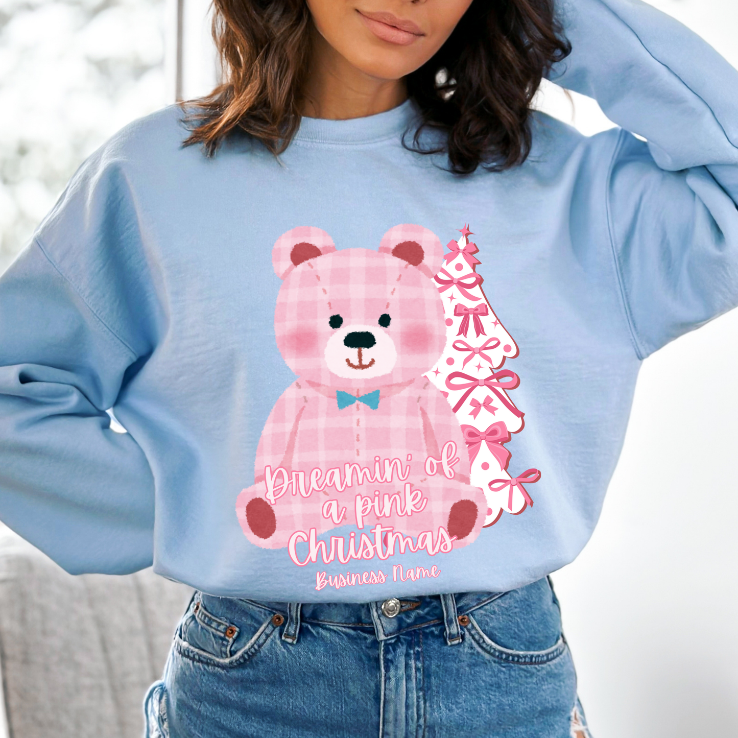 oversize pink plaid teddybear with white Christmas tree with pink bows on a blue sweatshirt. Text says Dreamin of a pink Christmas Customize with business name, city, state or both.