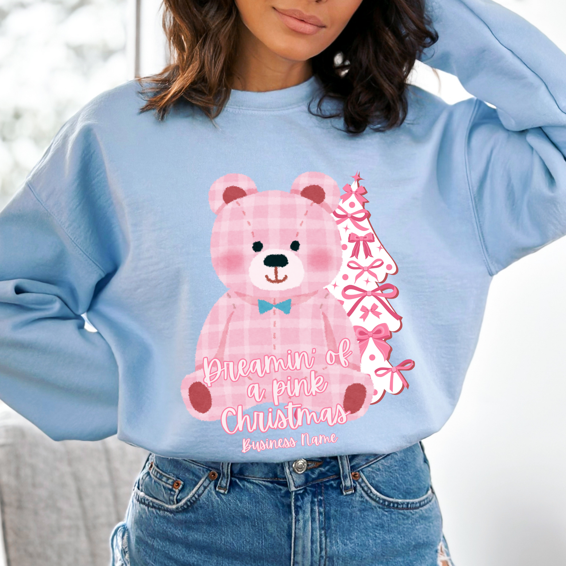oversize pink plaid teddybear with white Christmas tree with pink bows on a blue sweatshirt. Text says Dreamin of a pink Christmas Customize with business name, city, state or both.