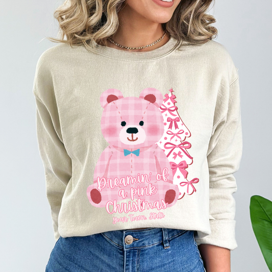 oversize pink plaid teddybear with white Christmas tree with pink bows on a beige sweatshirt. Text says Dreamin of a pink Christmas Customize with business name, city, state or both.