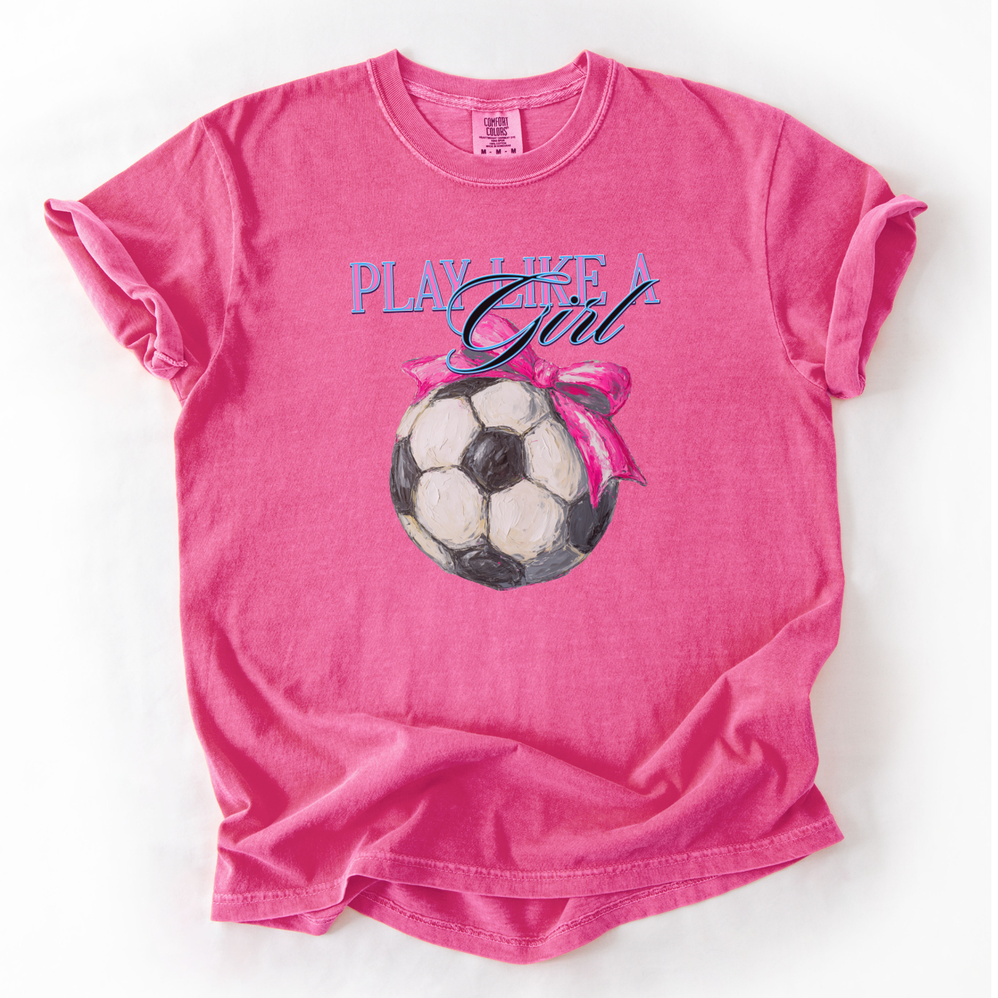 Pink t-shirt with soccer ball and 'Play Like a Girl' text on a white background
