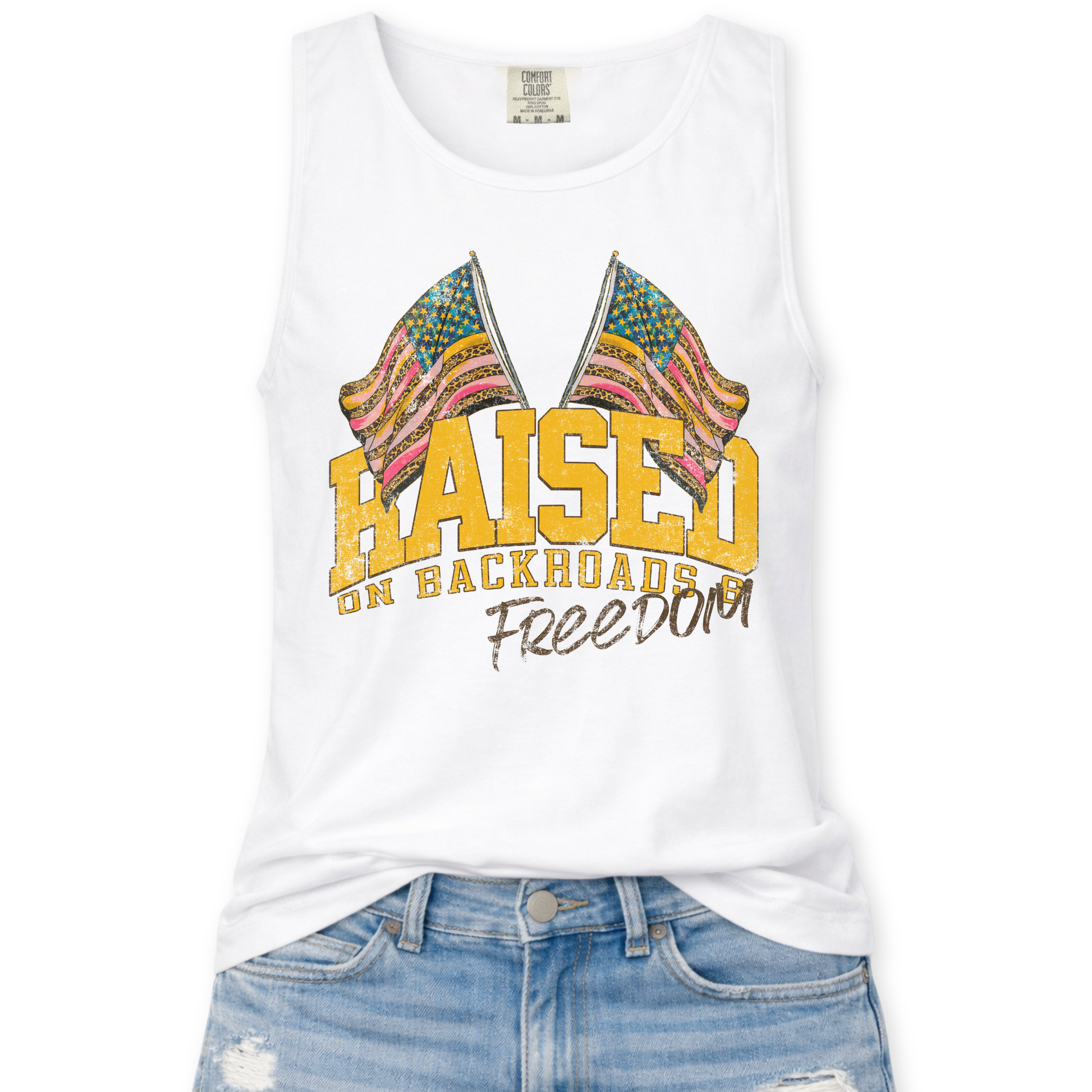 White tank top with colorful flag design and text 'Raised on Backroads and Freedom' on a white background.