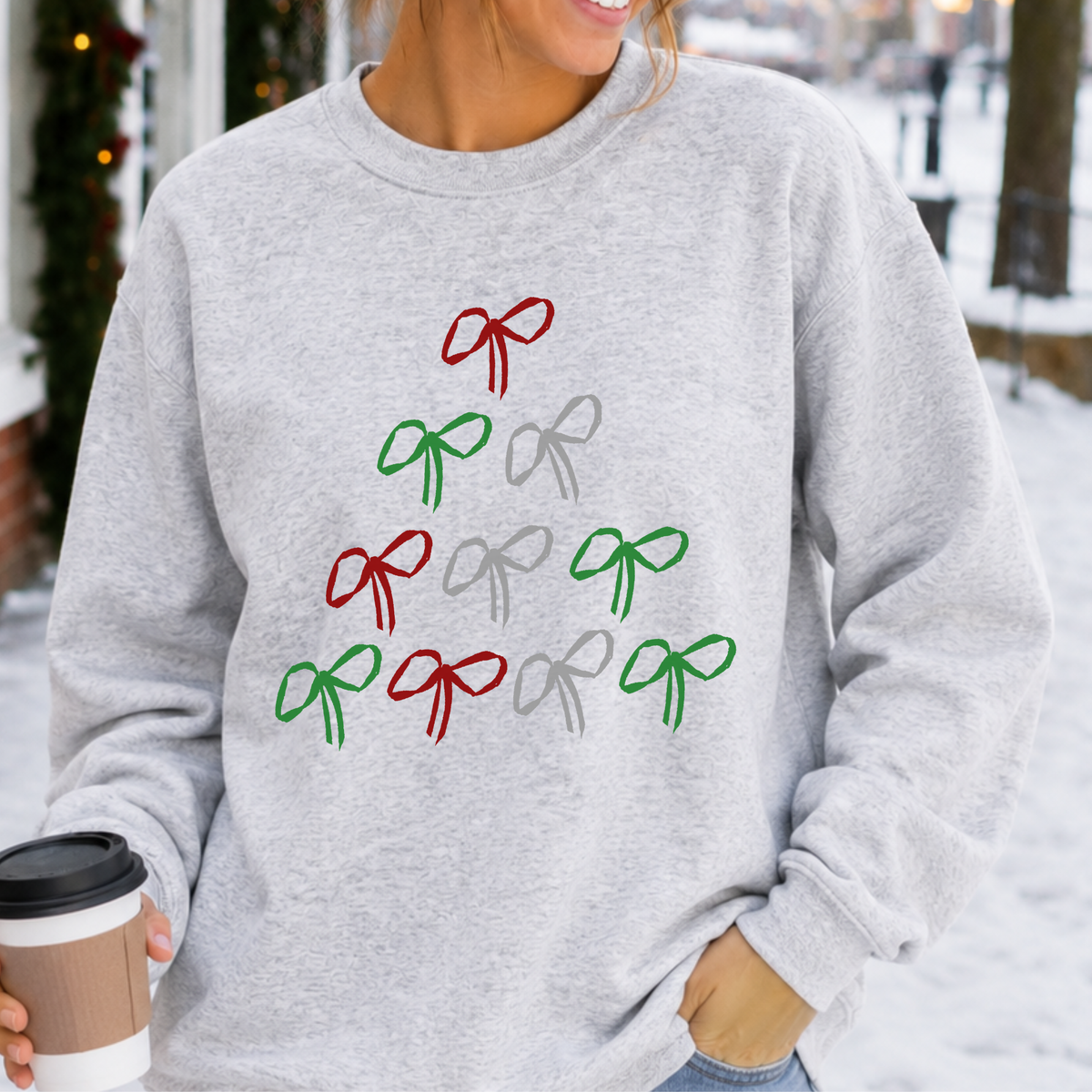 A simple Christmas tree made from hand-drawn bows in classic red, green, and silver on a ash gray color sweatshirt