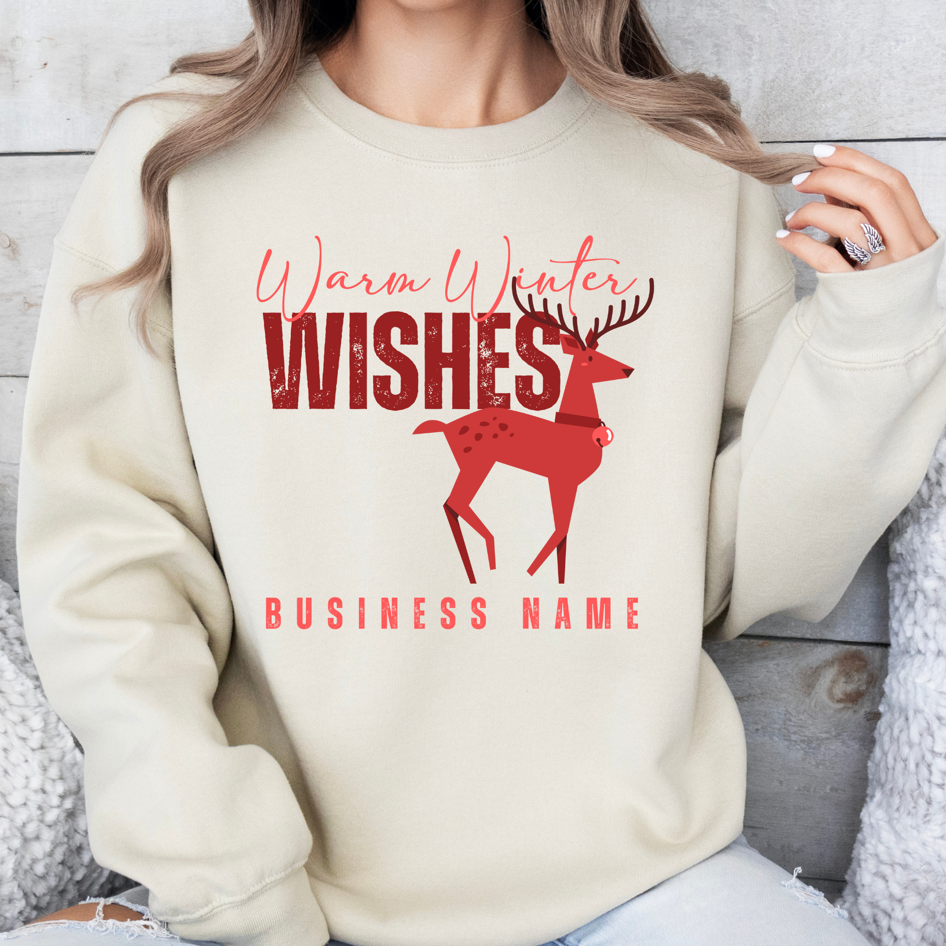 sand sweatshirt with red reindeer design That says Warm winter wishes in red. Below design is a place to customize the sweatshirt with your business name, town and state or both.
