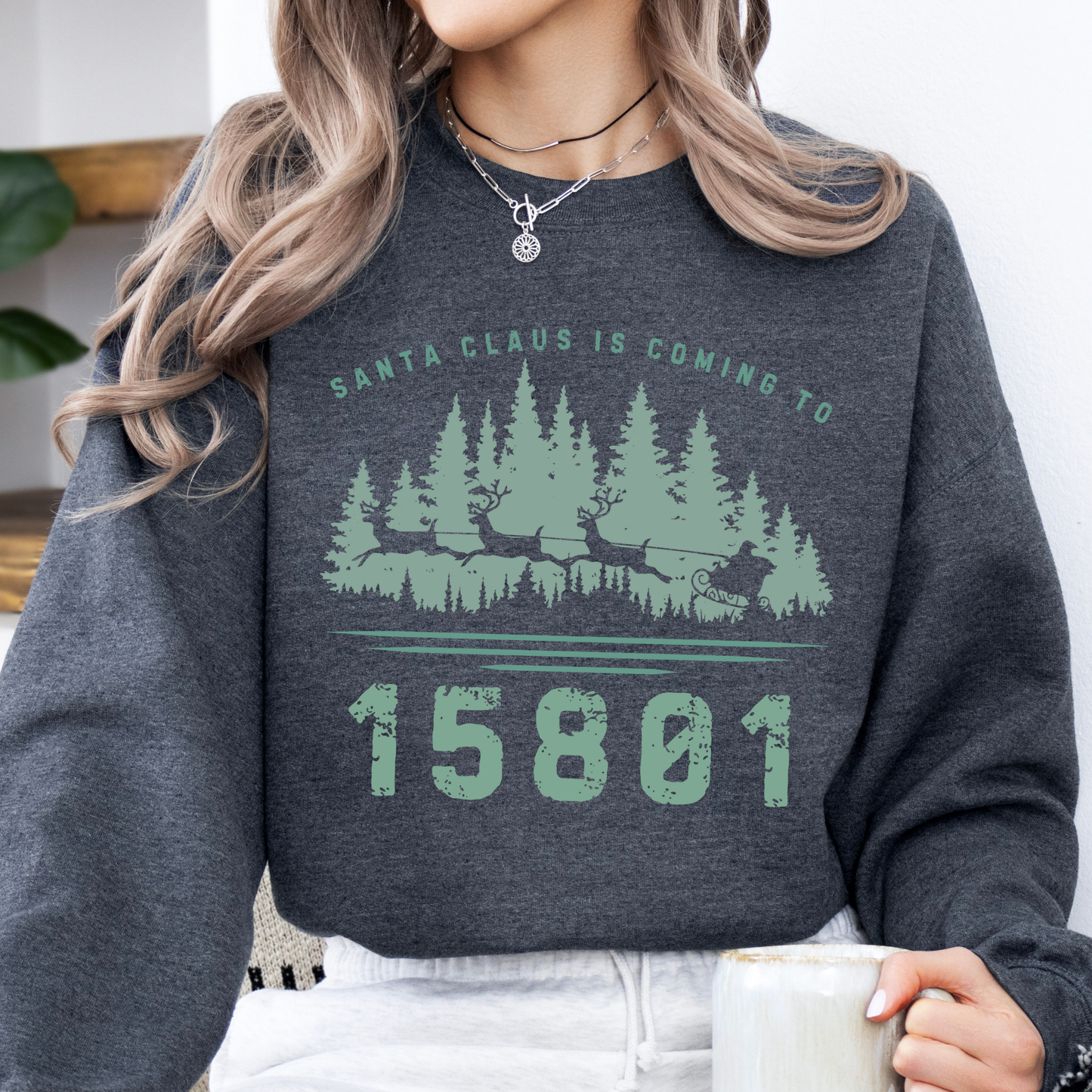 Custom Santa's coming to.  customize your city, state, zip code or business.  Santa's sleigh and reindeer flying over the forest on a dark heather gray sweatshirt.