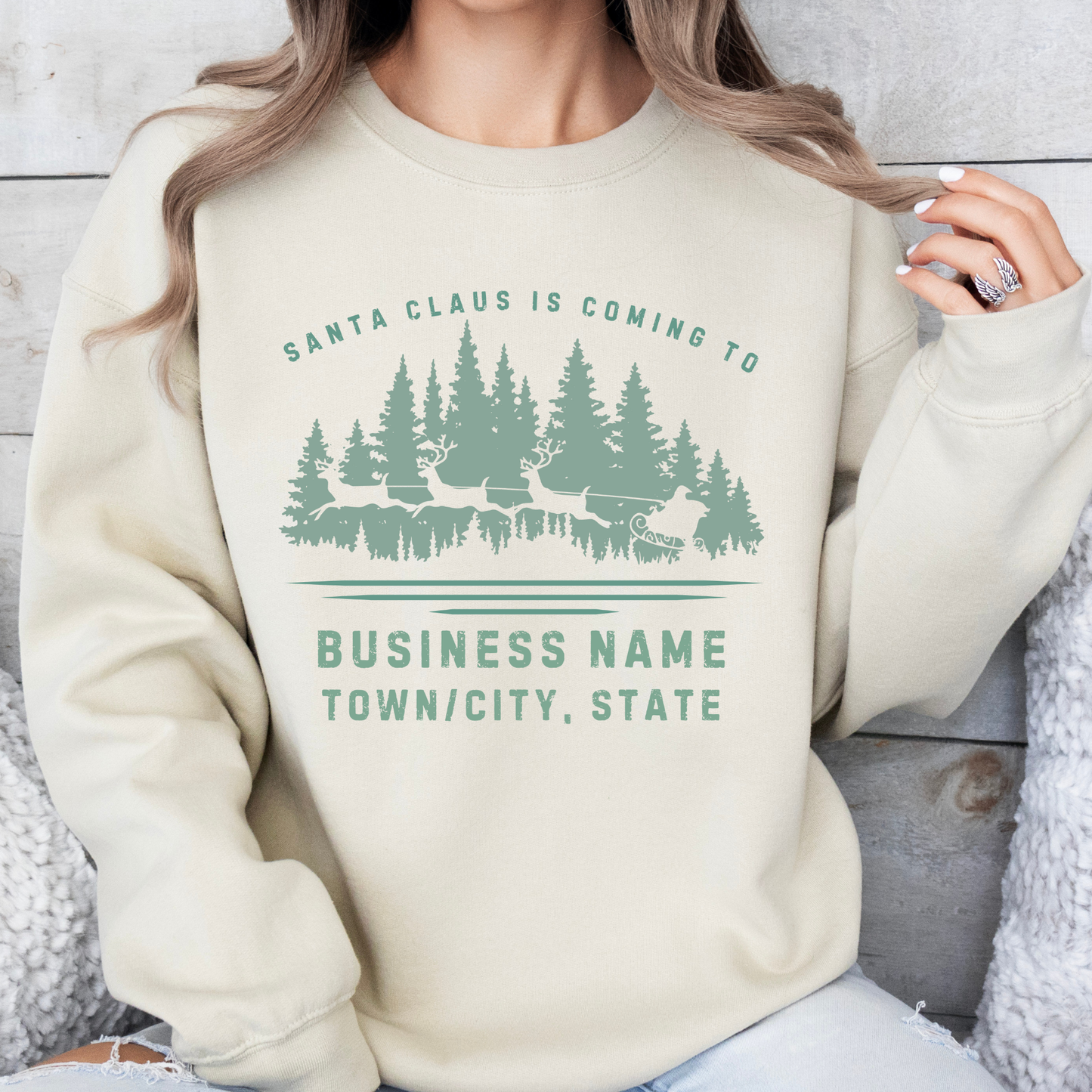 Custom Santa's coming to.  customize your city, state or business.  Santa's sleigh and reindeer flying over the forest on a beige sweatshirt.