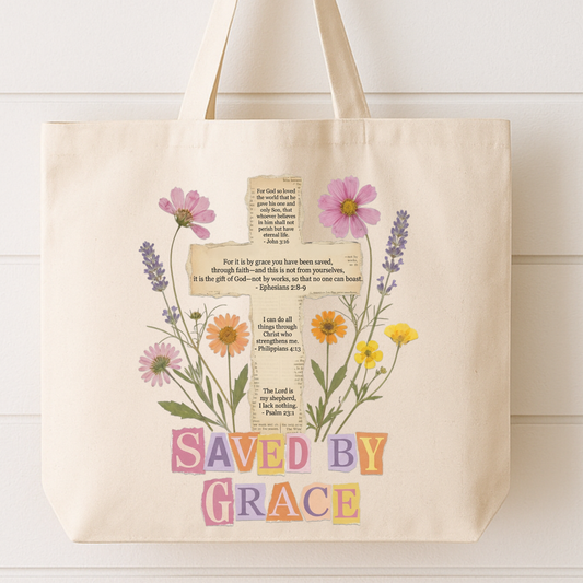 Tote bag with floral design and 'Saved by Grace' text on a white background