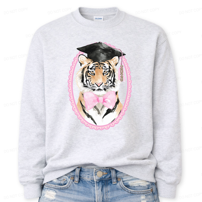 Gray sweatshirt with a tiger wearing a graduation cap and pink bow tie design on a white background.