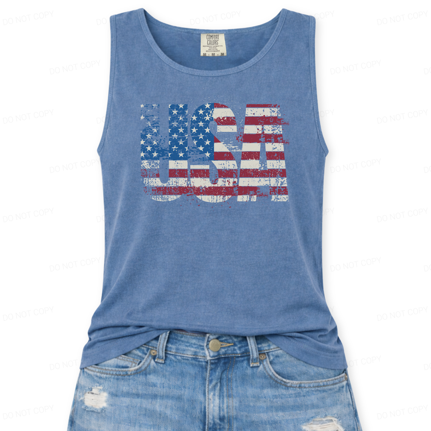 Distressed oversized "USA" overlayed with an American Flag on a Comfort Colors garment dyed unisex  blue tank top