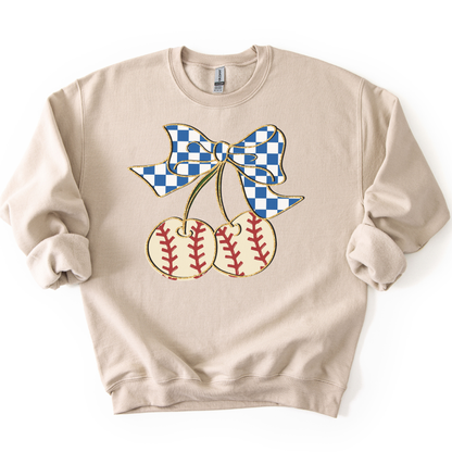 sand crewneck sweatshirt featuring a blue gingham bow tied to two cherry-shaped baseballs with red stitching, styled flat with sleeves scrunched