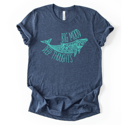 Coastal ocean graphic on a soft unisex heather navy graphic tee. The design features a stylized whale illustration with decorative swirl and line details inside the body, creating a clean sea life look. The phrase Big Mood appears above the whale, with Deep Thoughts arched below, forming a balanced layout that reads clearly from a distance. 