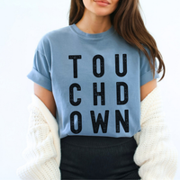 Person wearing a light blue t-shirt with 'TOUCHDOWN' text, white background