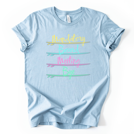 Surf themed beach graphic on a soft heather baby blue unisex graphic tee. The design features the phrase Mandatory Board Meeting Bye displayed across four stacked surfboards in bright summer colors including yellow, aqua, pink, and seafoam green. A lighthearted beach humor graphic that captures the feeling of skipping work for ocean time