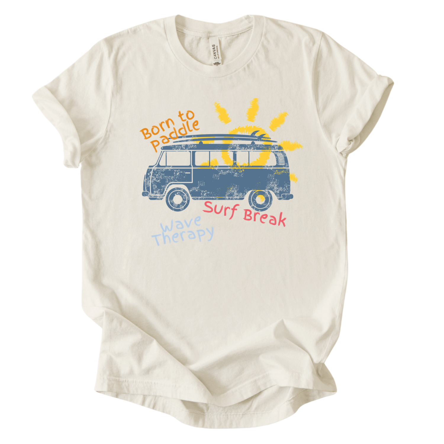 Summer beach graphic on a soft unisex heather oatmeal graphic tee. The design features a vintage surf van illustration with a surfboard on top and a bright sun rising behind the vehicle. Playful coastal phrases including Born to Paddle, Surf Break, and Wave Therapy surround the artwork, creating a relaxed surf and beach lifestyle graphic that captures the feeling of ocean days and summer travel.