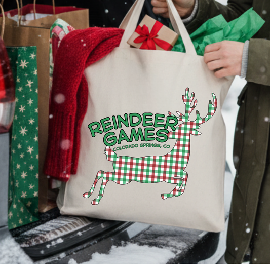 Canvas tote bag with a large red and white checkered reindeer.  Tote says reindeer games.  Customizable tote with business name, city and state or both