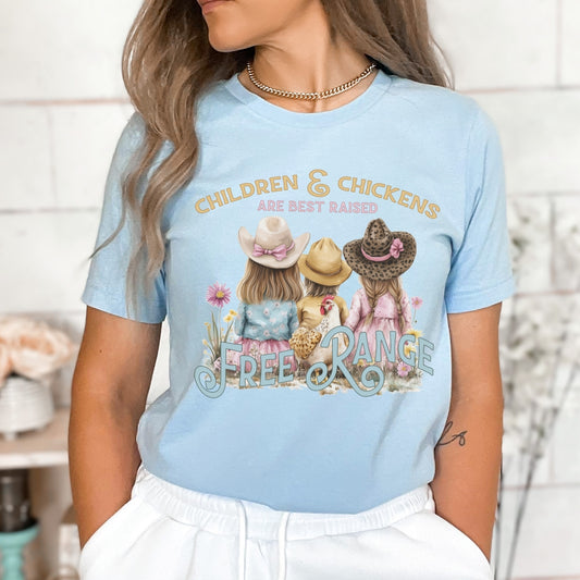 Children and chickens are best raised free range featuring 3 cute kids with a chicken in a flower field. on a heather baby blue t-shirt