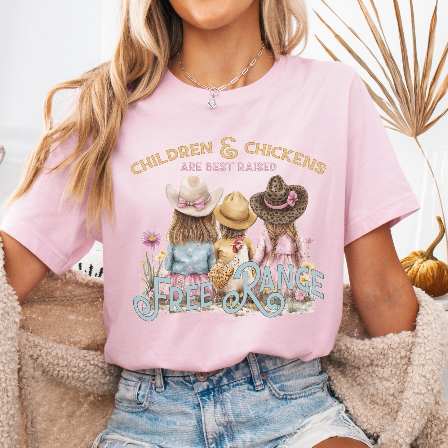 Children and chickens are best raised free range featuring 3 cute kids with a chicken in a flower field. on a heather pink t-shirt
