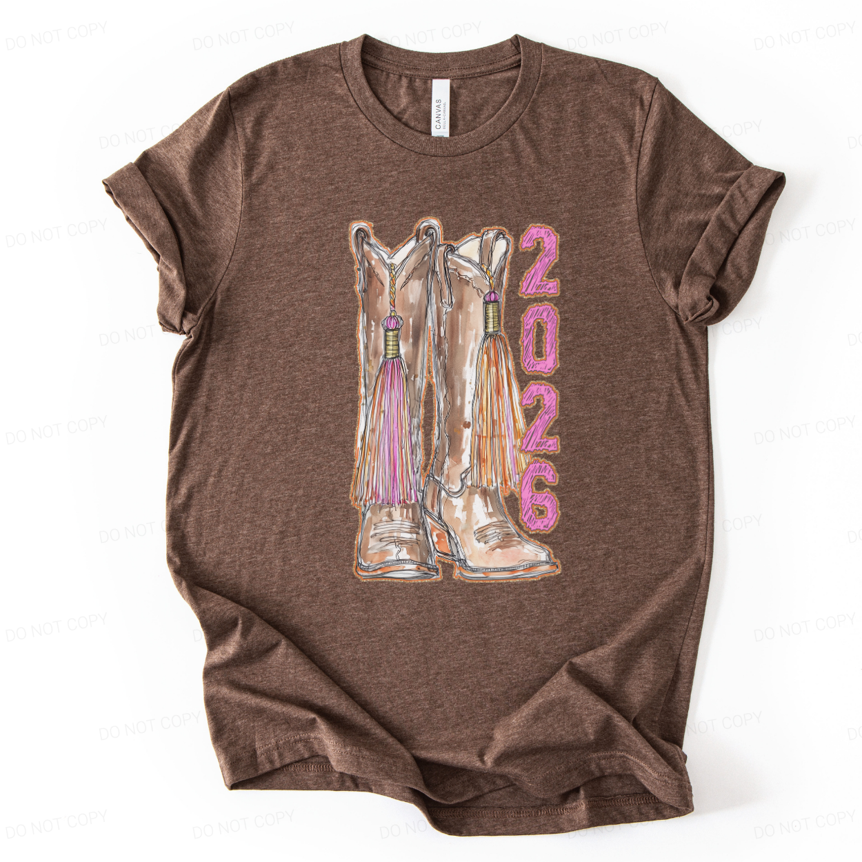 Heather brown Graduation western themed graphic t shirt. The design features a detailed illustration of cowgirl boots accented with tassels, paired with vertical 2026 lettering in pink for strong senior year visibility. 