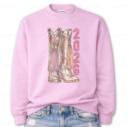 Pink sweatshirt with cowboy boots and '2026' printed on it, worn with denim shorts.
