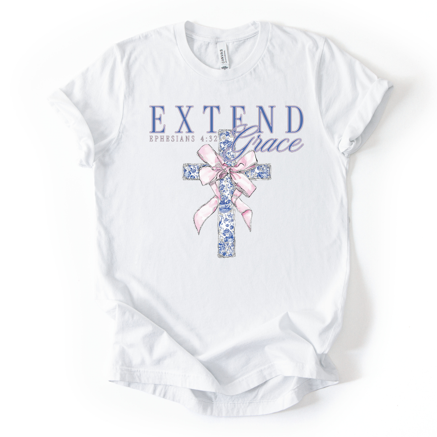 White t-shirt with floral cross and 'Extend Grace' text on a white background.The graphic features an illustrated cross filled with a blue floral pattern, tied with a soft pink ribbon bow at the center. Above the cross, the words “Extend Grace” appear in layered lettering, paired with the scripture reference Ephesians 4:32.