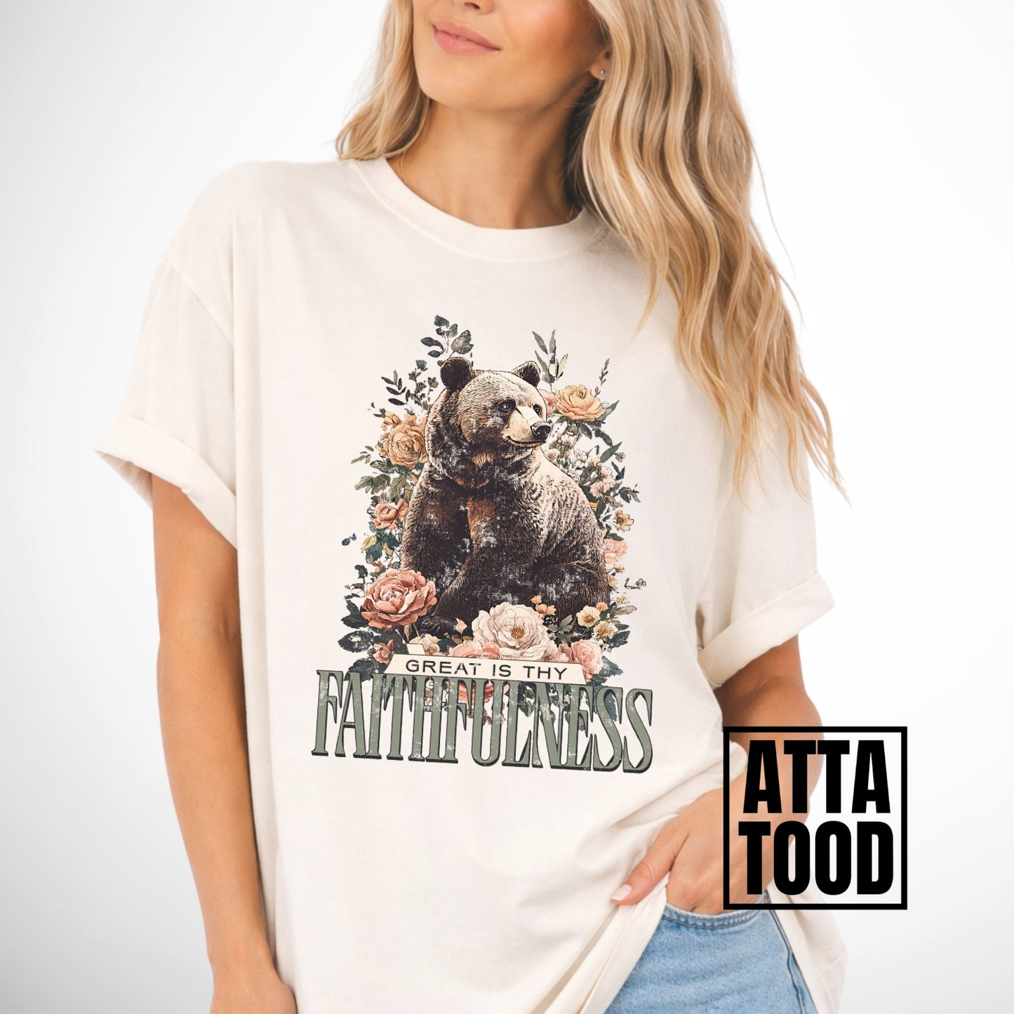 Person wearing a white t-shirt with a bear and floral design, text 'Great is thy faithfulness', and 'Atta Tood' branding.