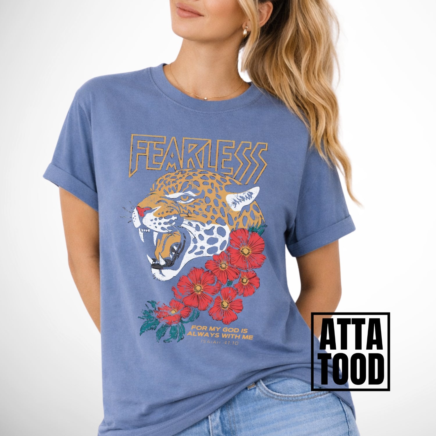 Woman wearing a blue comfort colors t-shirt with a leopard and floral design, labeled 'ATTA TOOD'. Fearless for my God is always with me