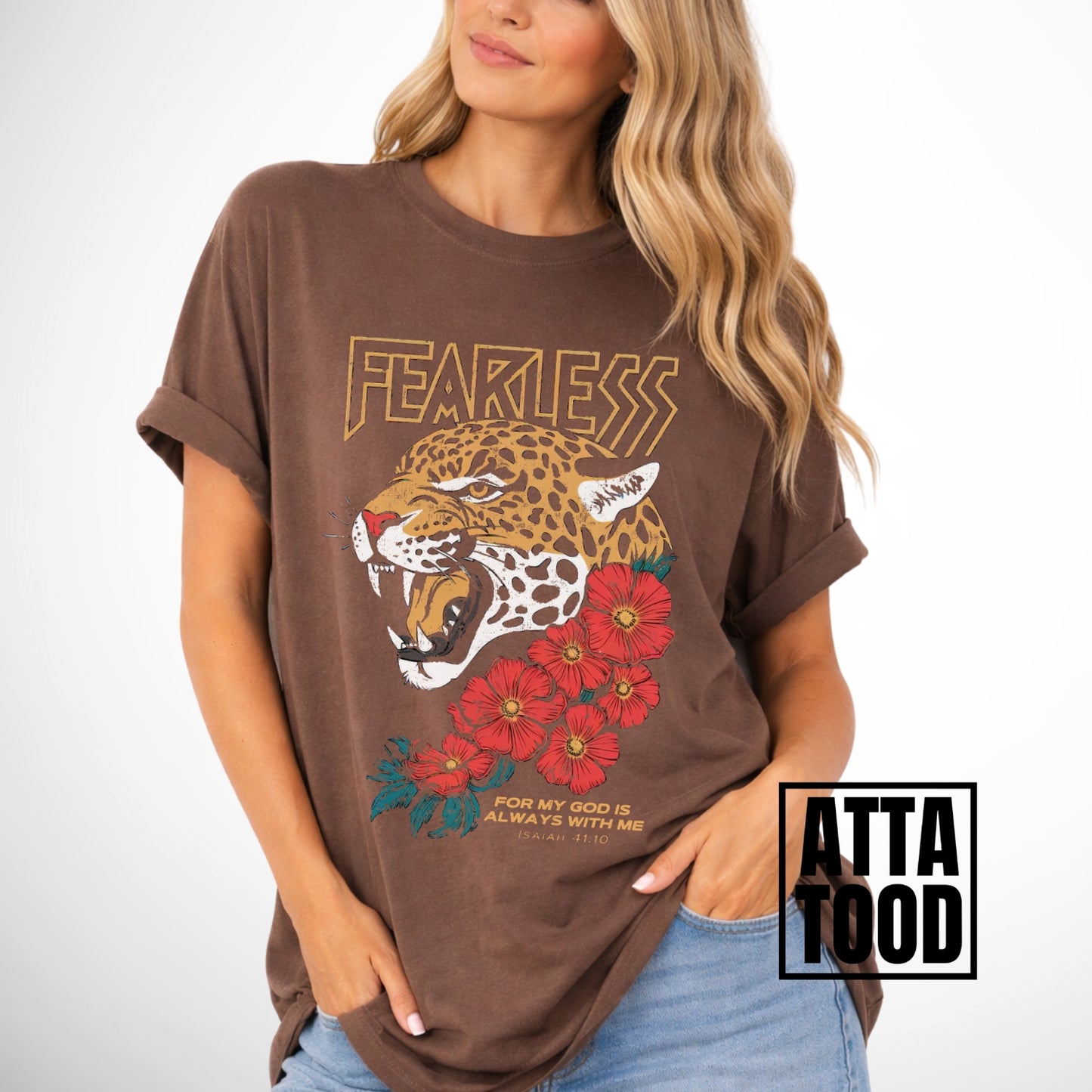 Woman wearing a brown comfort colors t-shirt with a leopard and floral design, labeled 'ATTA TOOD'. Fearless for my God is always with me