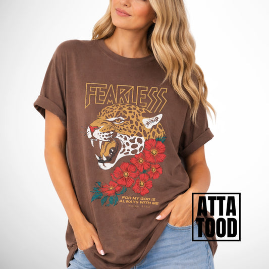 Woman wearing a brown comfort colors t-shirt with a leopard and floral design, labeled 'ATTA TOOD'. Fearless for my God is always with me