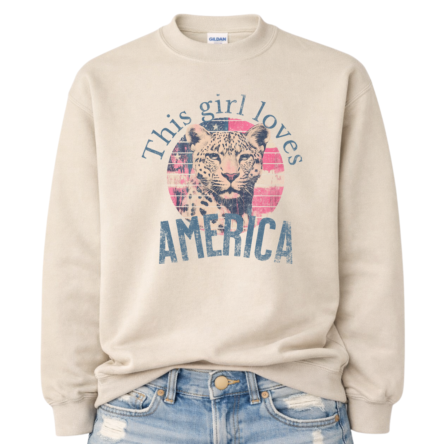 Beige sweatshirt with a graphic of a leopard and text 'This girl loves America' on a white background.