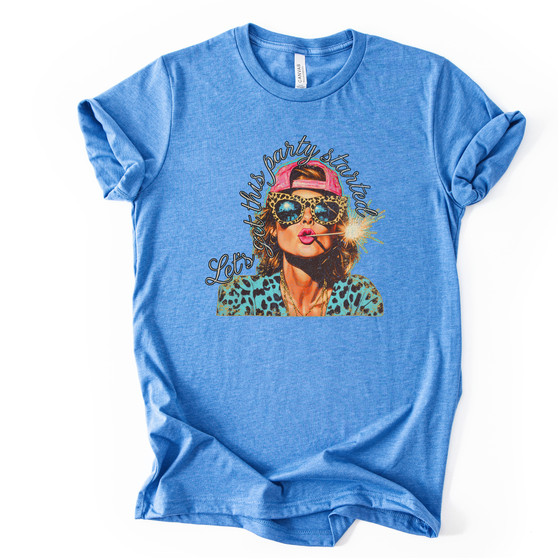 blue Patriotic Fourth of July graphic on a white  t-shirt. The design features an illustrated woman wearing leopard-print sunglasses and a backward cap, holding a lit sparkler with fireworks reflected in the lenses. Curved script lettering adds a playful party vibe, blending bold Americana colors with a modern, fun-forward patriotic style ideal for summer celebrations.