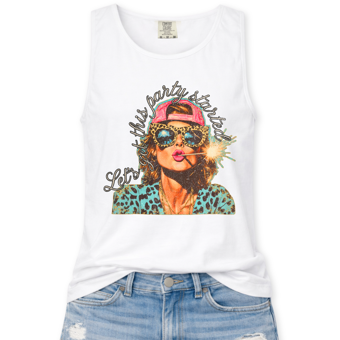 white Comfort Colors tank top featuring a colorful patriotic graphic of a woman wearing leopard print sunglasses and a pink hat holding a sparkler with the phrase “Let’s Get This Party Started,” styled with light wash denim jeans.