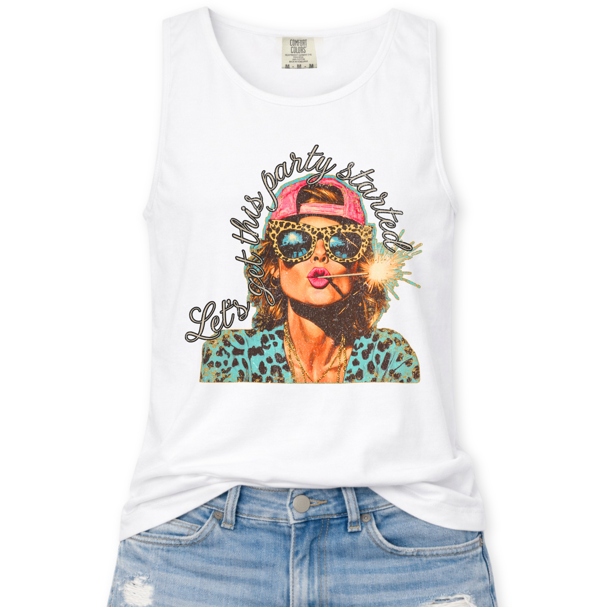 white Comfort Colors tank top featuring a colorful patriotic graphic of a woman wearing leopard print sunglasses and a pink hat holding a sparkler with the phrase “Let’s Get This Party Started,” styled with light wash denim jeans.