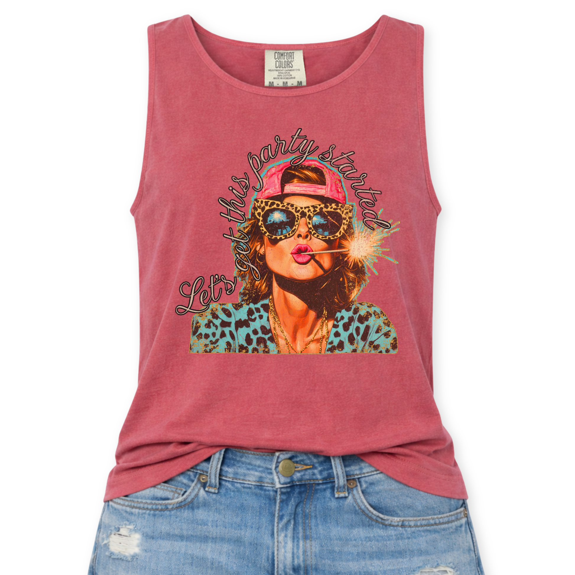 Crimson red Comfort Colors tank top featuring a colorful patriotic graphic of a woman wearing leopard print sunglasses and a pink hat holding a sparkler with the phrase “Let’s Get This Party Started,” styled with light wash denim jeans.